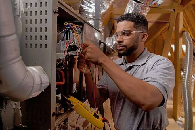Technician inspecting the wiring inside a heating system