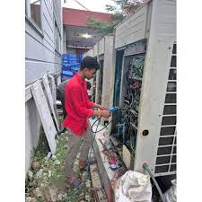 Technician checking components inside an outdoor HVAC unit