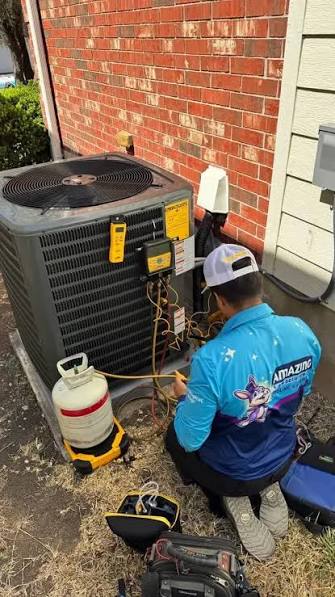 Technician checking a residential air conditioner with service gauges